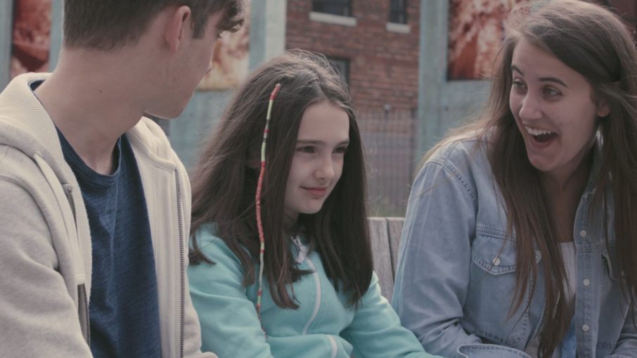 Rob, Mia and Emma sit on a bench