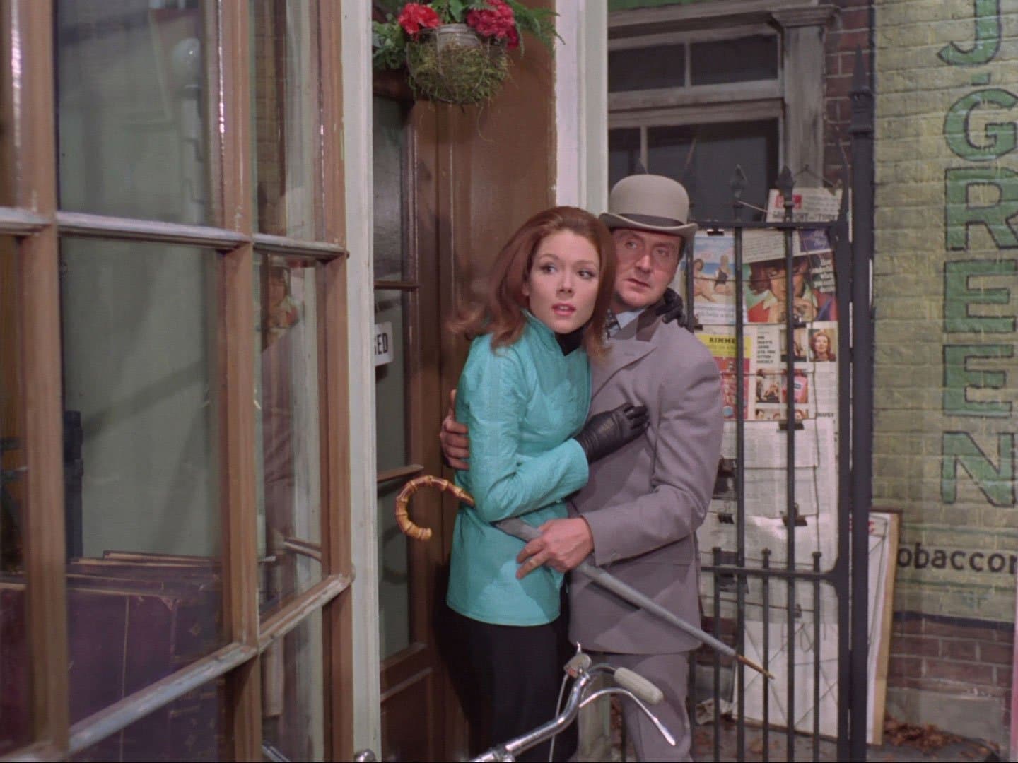 Emma Peel and John Steed cower in a doorway