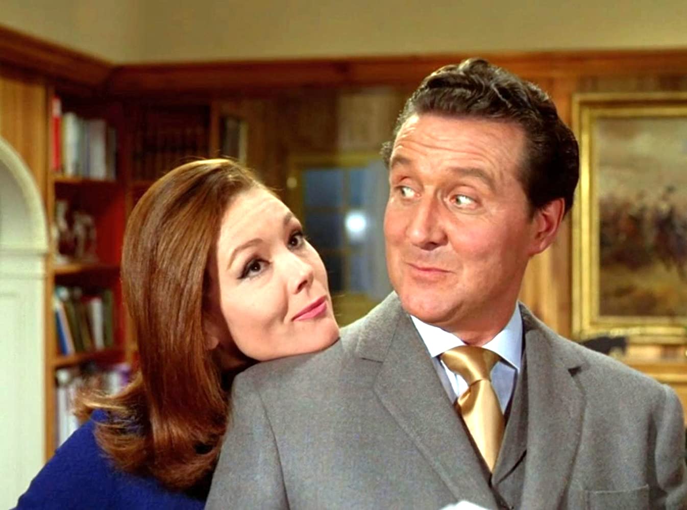 Emma Peel rests her chin on John Steed's shoulder